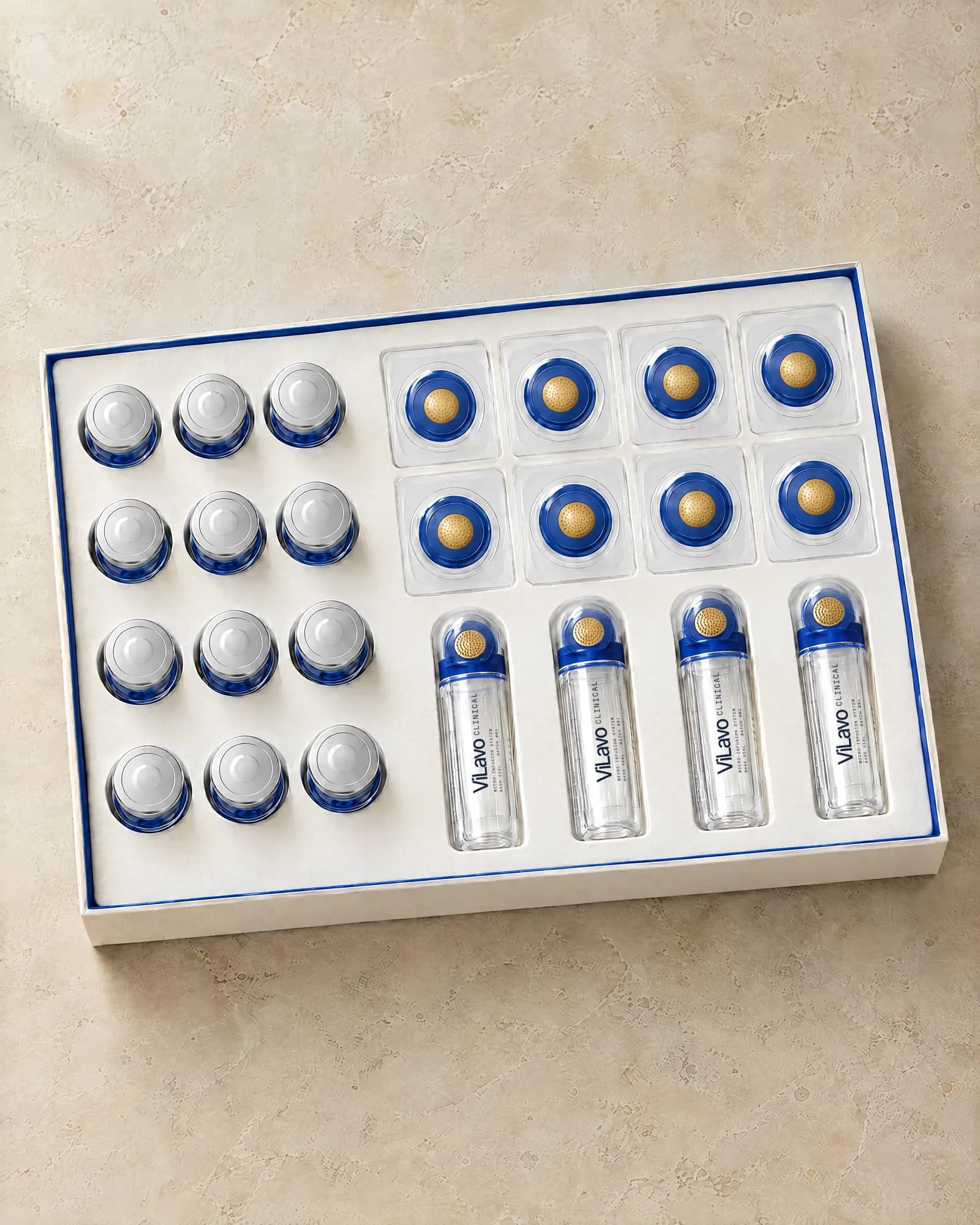 The ViLavo Clinical kit open in a molded tray: rows of blue serum vials, sealed micro-infusion heads and clear base vials.