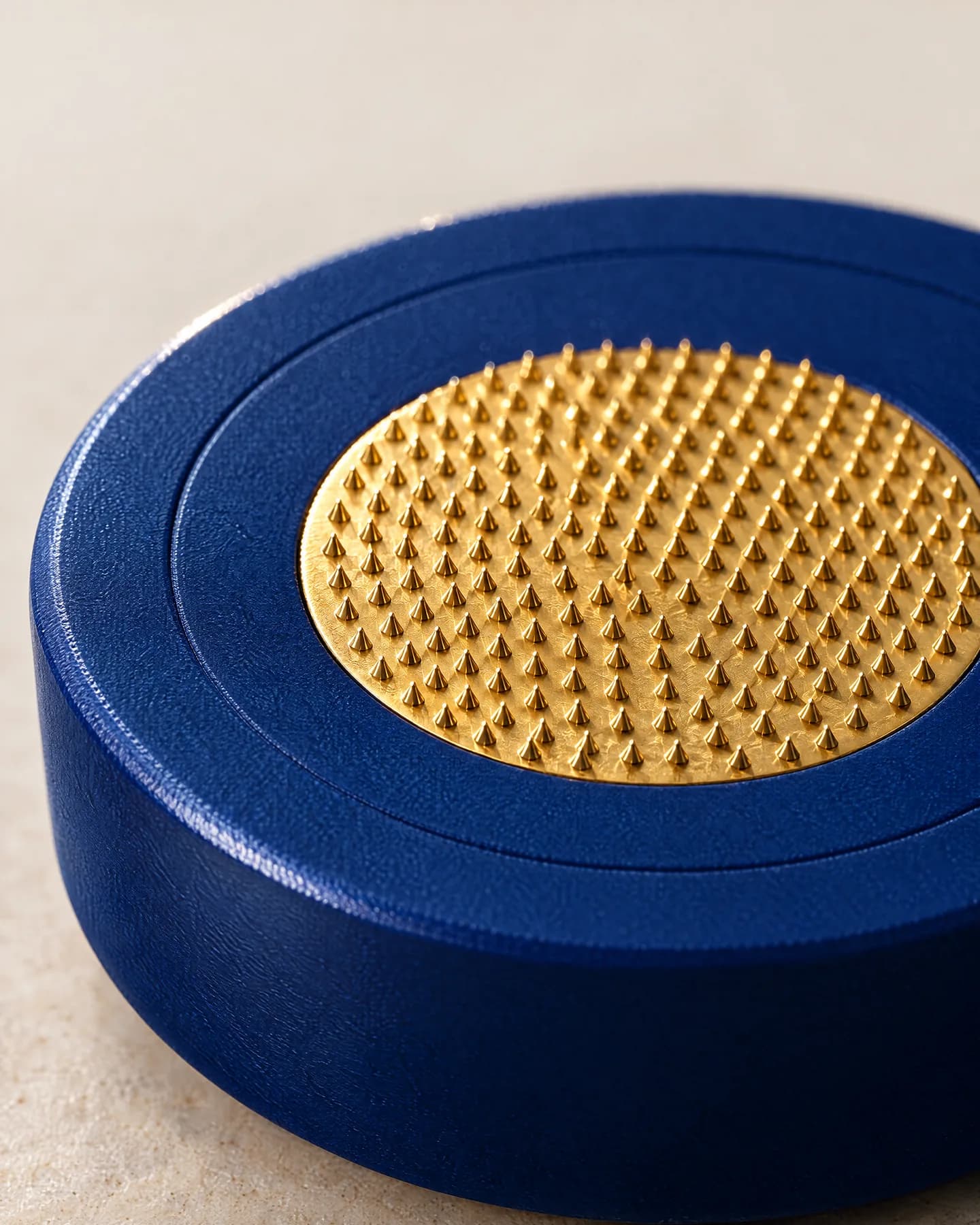Close view of the gold micro-needle pad of a single-use head: rows of fine raised tips inside a deep-blue collar.